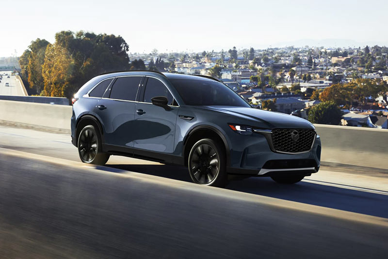 2026 Mazda CX-90 Turbo S Premium Sport driving on city highway, side view
