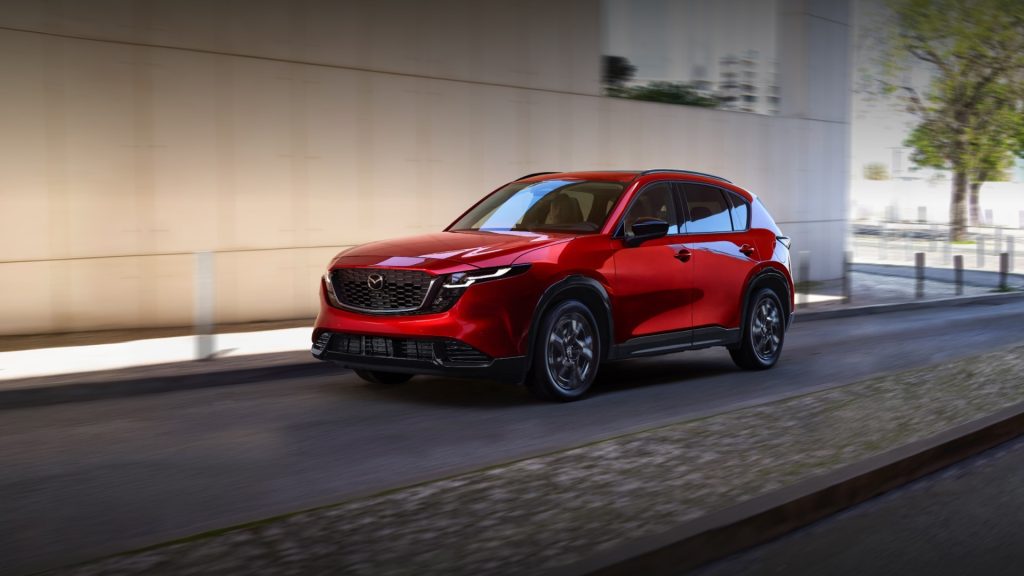 Red 2026 Mazda CX-5 driving on an urban road.